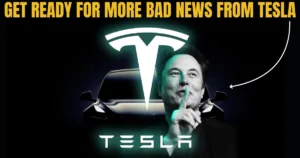 A dark-themed promotional image with bold yellow text at the top reading “Get Ready for More Bad News from Tesla.” In the center, the Tesla logo glows above a shadowy Tesla car. Elon Musk is in the foreground, making a "shushing" gesture with his finger, suggesting secrecy or suspense. A white arrow points toward him, adding visual emphasis. The overall tone is dramatic and mysterious.