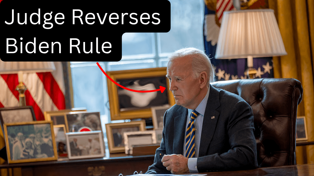 President Biden seated at the Oval Office desk looking serious, with overlaid text ‘Judge Reverses Biden Rule’ and a red arrow pointing toward him, highlighting the overturned medical-debt credit policy.