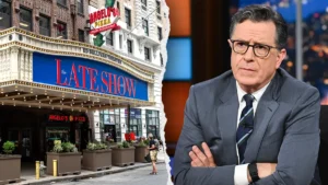The Late Show with Stephen Colbert marquee at Ed Sullivan Theater alongside a serious-looking Stephen Colbert on set.